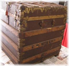 A Large flat top before restoration. Notice the heavy ornate metal corner protectors.